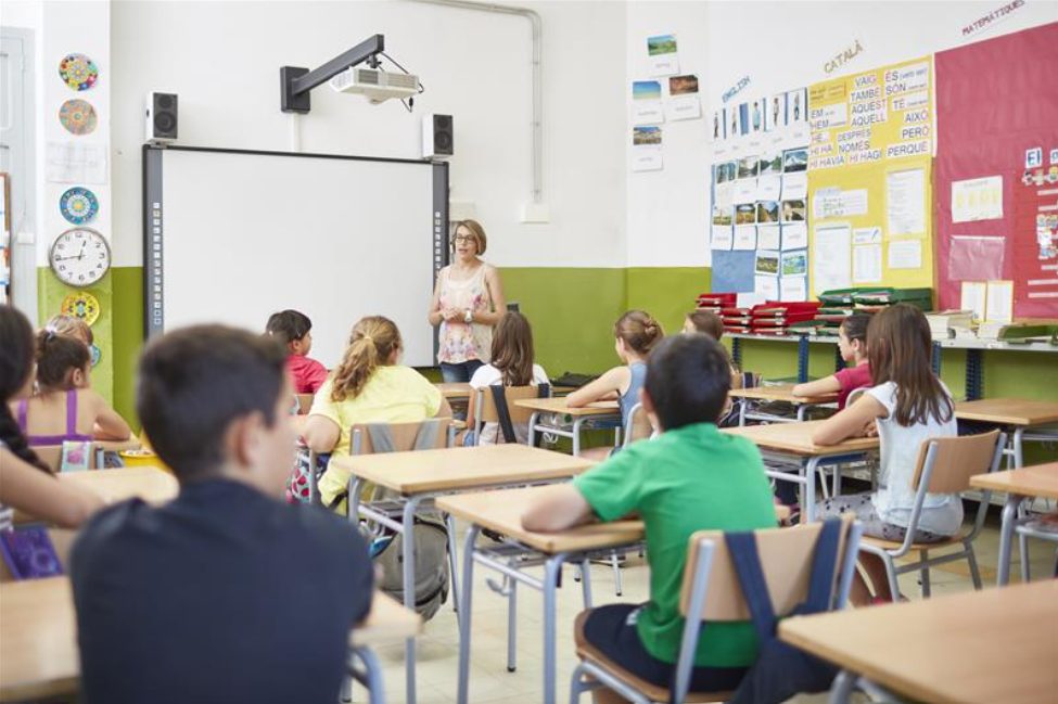 A teacher standing in front of a classroom filled with students.